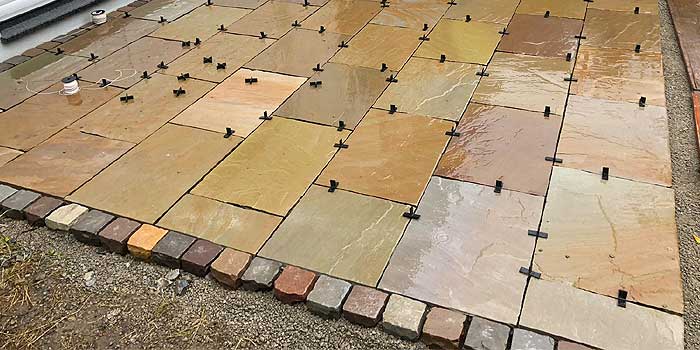 Frisch verlegte Sandsteinplatten mit Einfassung aus Kleinpflaster